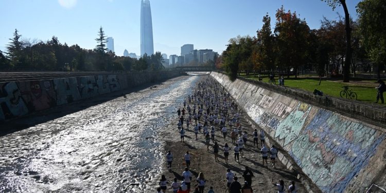 Corredores participam de uma corrida ao longo das margens do rio Mapocho, em Santiago, que passou por processo de despoluição — Foto: Rodrigo Arangua / AFP