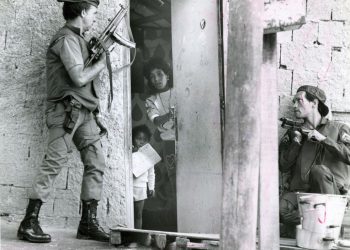 Moradora do Dona Marta entre policiais armados, em 1987 — Foto: Frederico Rozário/Agência O GLOBO