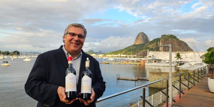 O enólogo Tiago Garcia com os vinhos Monsaraz Grande Reserva Branco e Tinto — Foto: Cláudia Meneses / Agência O Globo