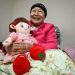 Kim Young-bun, uma idosa sul-coreana que vive sozinha, segurando Hyodol, uma boneca de saúde com inteligência artificial projetada para idosos — Foto: Jung Yeon-Je / AFP