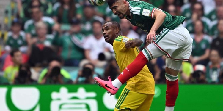 O zagueiro mexicano Vasquez disputa bola pelo alto contra o atacante sul-africano Rayners, na estreia da Copa de 2026 — Foto: Yuri Cortez/AFP