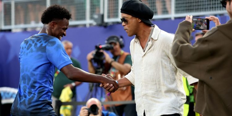 Vini e Ronaldinho Gaúcho se encontram antes de Brasil x Haiti pela Copa do Mundo — Foto: Dan Mullan / Getty Images via AFP