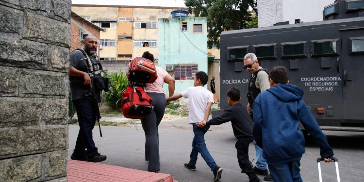 Entre fuzis e blindados, crianças cruzam cerco policial após agente levar tiro na cabeça no Muquiço