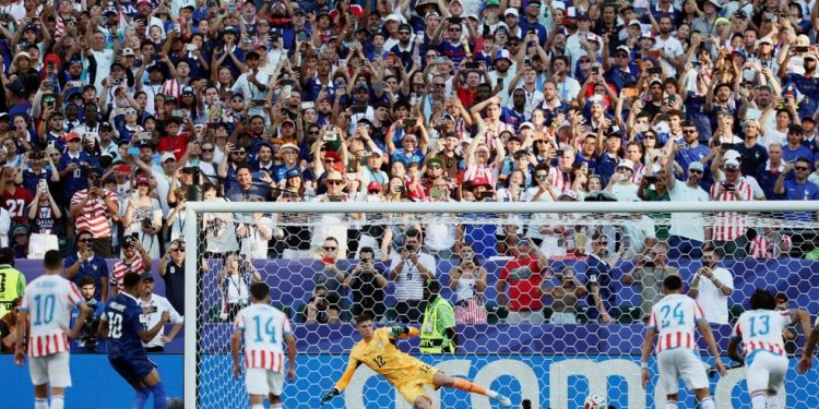 O atacante #10 da França, Kylian Mbappe, chuta de pênalti para marcar o primeiro gol de sua equipe durante a partida de futebol das oitavas de final da Copa do mundo de 2026 entre Paraguai e França — Foto: FRANCK FIFE /AFP