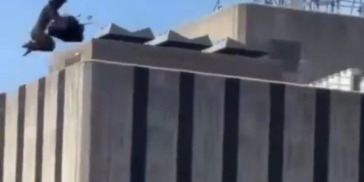 Homem escala ponte dos EUA, pendura bandeiras e salta nu em rio diante de turistas; vídeo