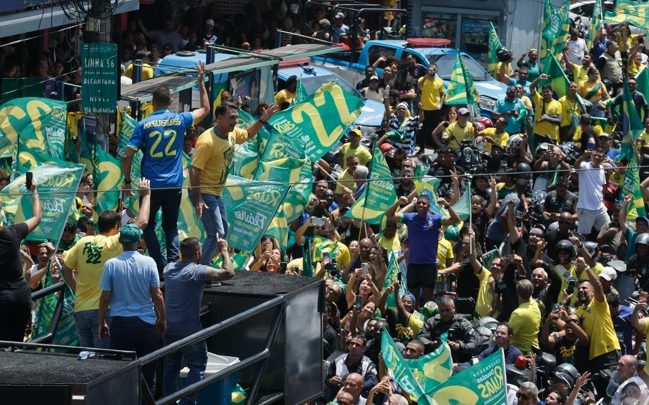 Já projetando dia de posse, Flávio promete entregar 'Brasil nas mãos de Deus' e Jair Bolsonaro colocando faixa presidencial